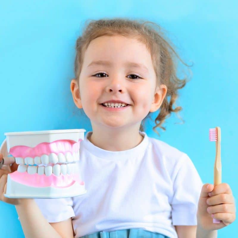 Smiling girl practicing oral health.