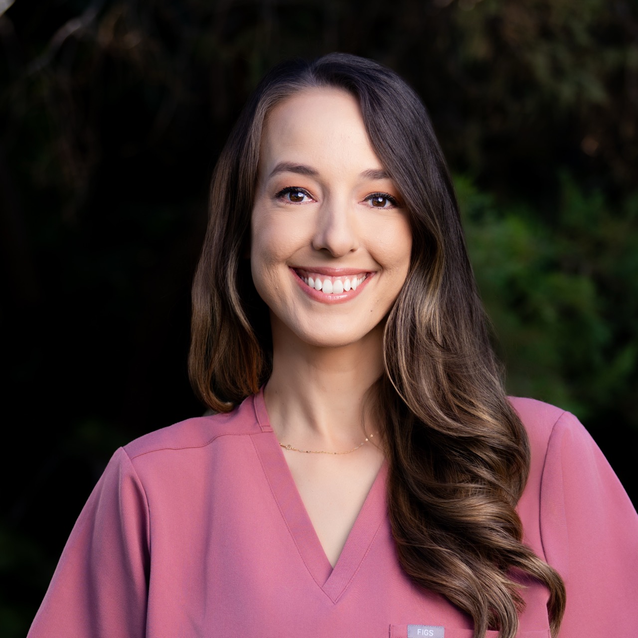 Smiling woman outdoors in pink blouse