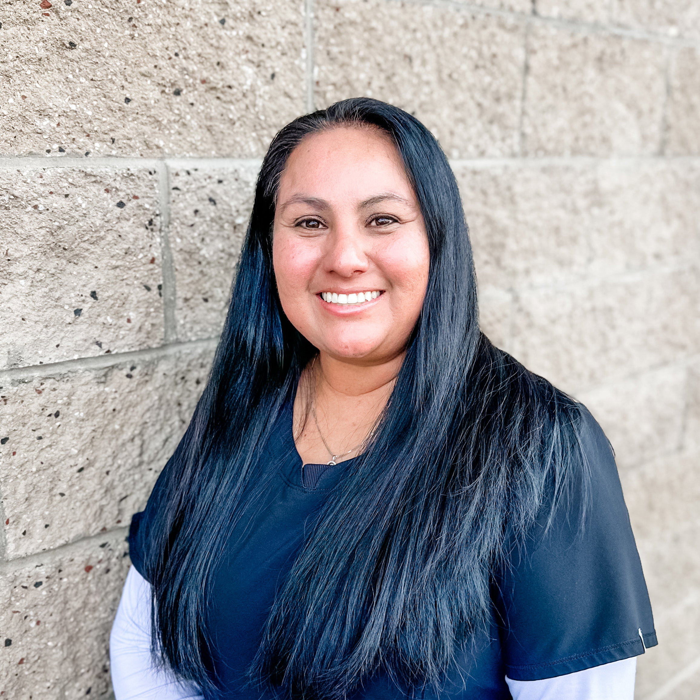 Smiling woman in front of brick wall